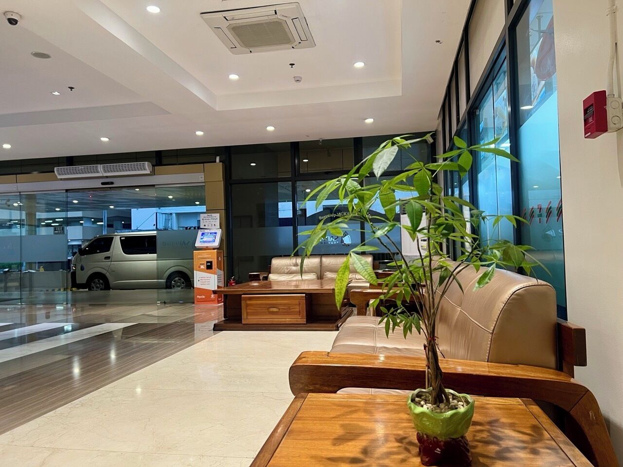 A modern lobby with a reception desk, seating area, and a large window.