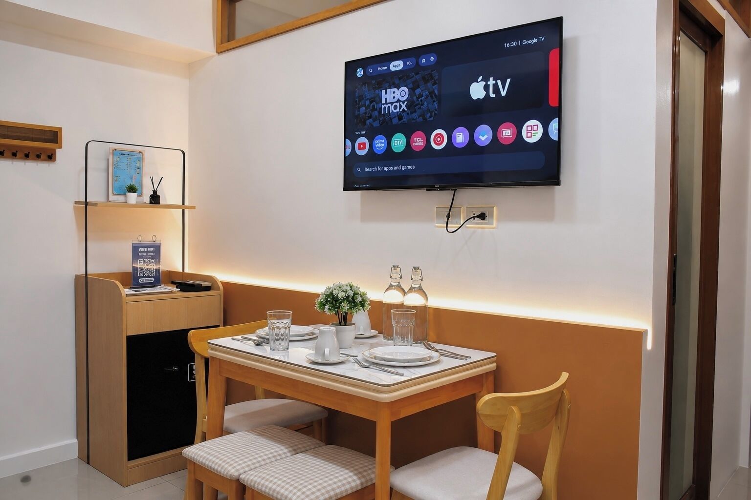 Une chambre d’hôtel moderne dotée d’un téléviseur à écran plat fixé au mur, permettant d’accéder aux applications HBO Max et Apple TV.