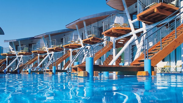 A pool area with multiple wooden and metal staircases leading to balconies. - Paloma Sencia (Serik)