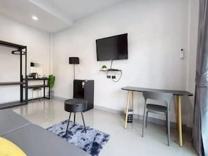 Una sala de estar moderna con un televisor de pantalla plana, una mesa de comedor y un sofá.