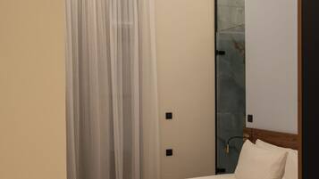 Un dormitorio moderno con una cama de madera, un espejo grande y un techo con diseños intrincados.
