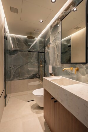 Suite estudio Deluxe, 1 cama de matrimonio, no fumadores, vistas a la ciudad | Baño | Ducha, secador de pelo, toallas y jabón