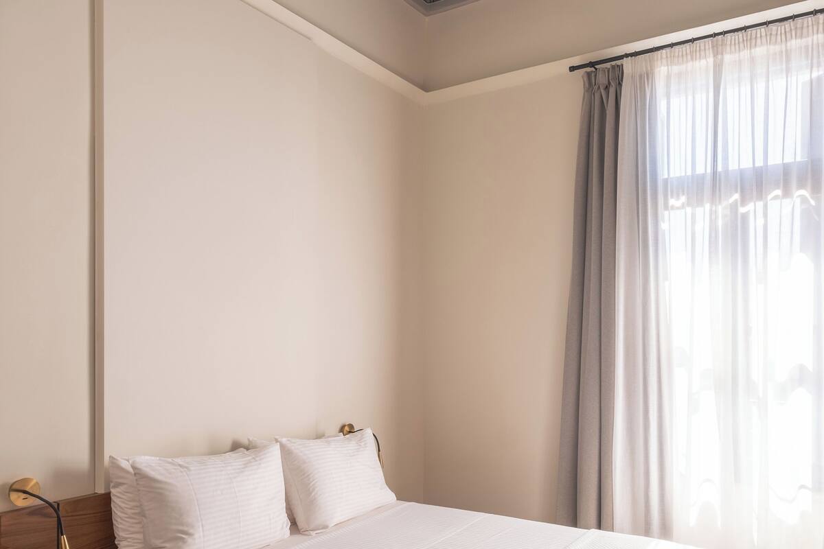 Quarto com cama, escrivaninha e cadeira.