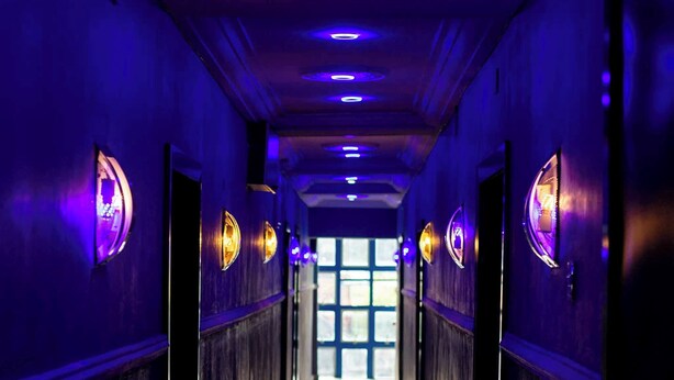 A hallway with a reflective floor, wooden paneling on the walls, and recessed lighting. - New Eastern Comfort Hotel Umuahia (Umuahia)