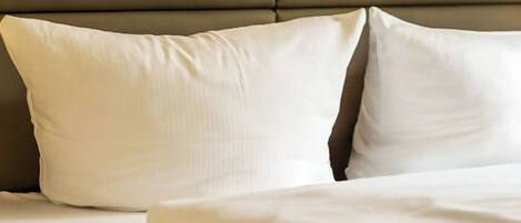 A bed with white bedding and a headboard.