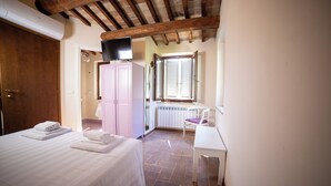 Une chambre à coucher avec un lit, un bureau, une chaise et une fenêtre.