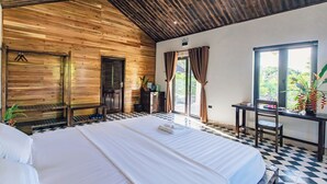 A room with a large bed, wooden ceiling, a desk with a chair, and a window with curtains. - Dong Giao Bungalow Ninh Binh (Trung Son)