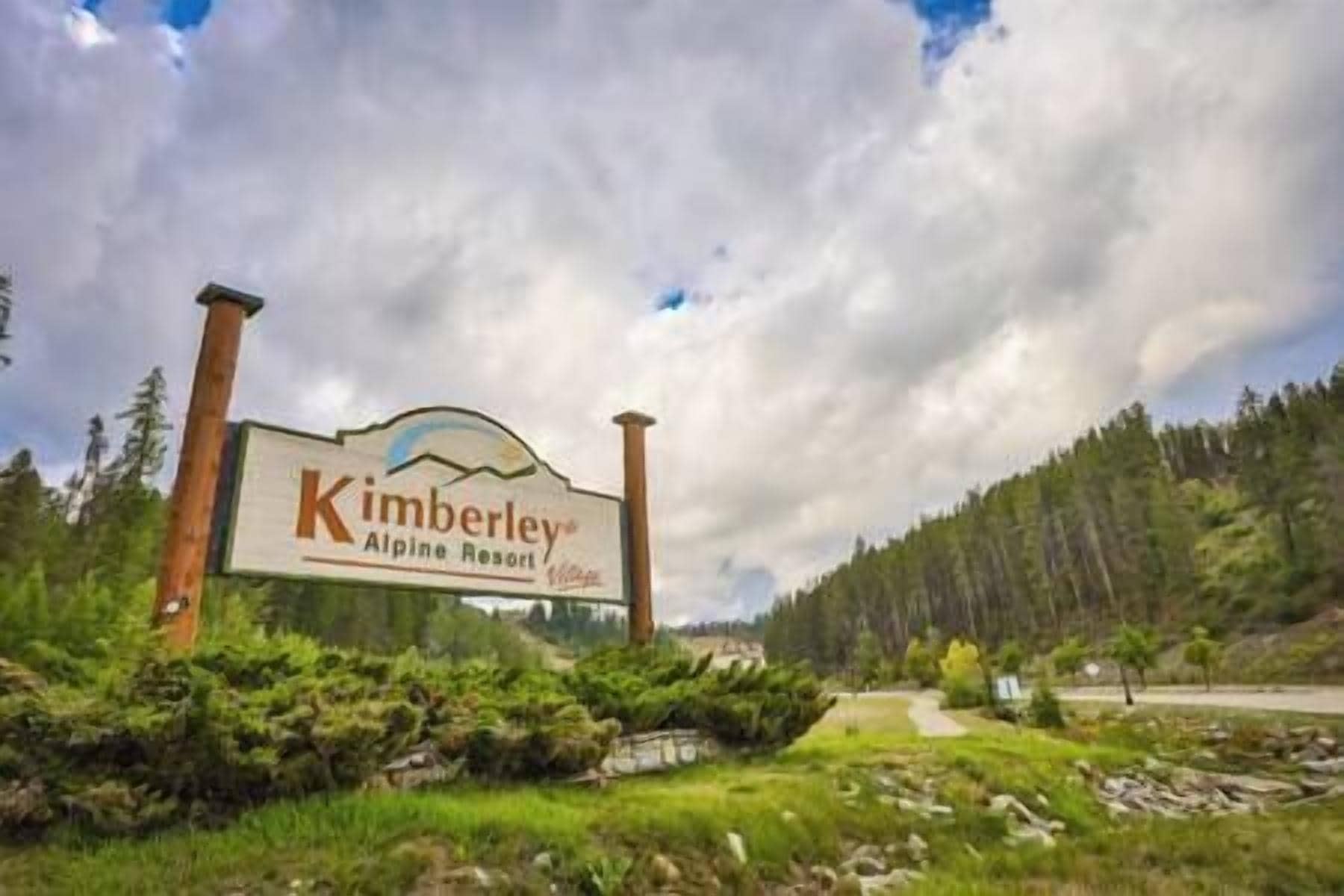 En skylt för Kimberley Alpine Resort med ett naturligt landskap i bakgrunden.