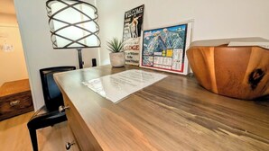 Un comptoir d’accueil en bois, avec une lampe, un panneau d’accueil, une carte et une chaise en bois.