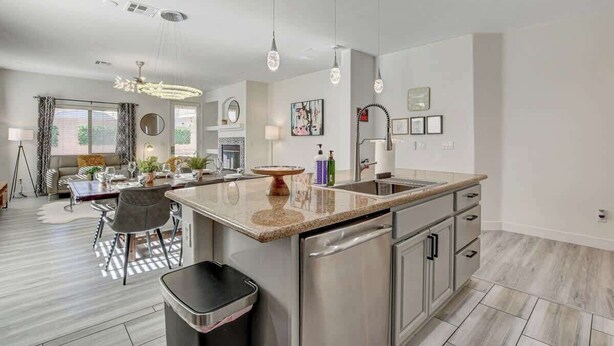 A modern kitchen with a central island, stainless steel appliances, and pendant lighting.