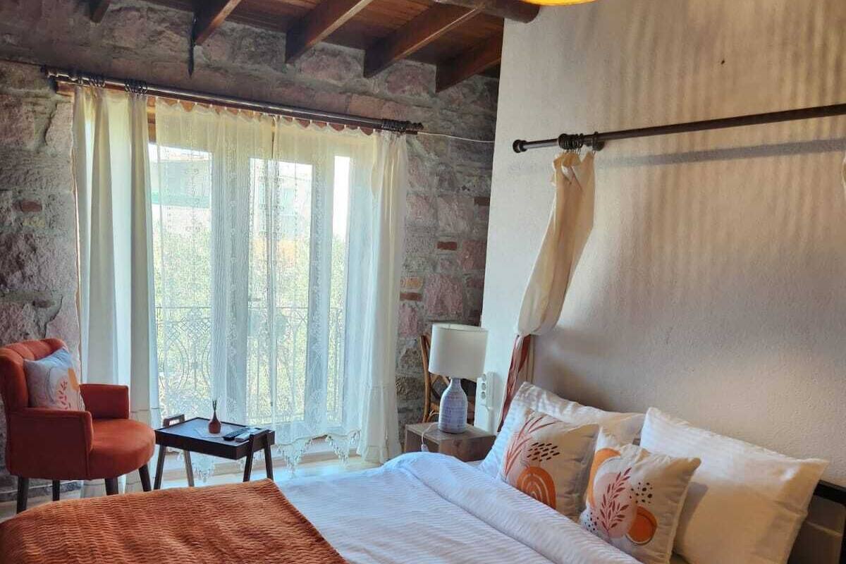 Ein gemütliches Schlafzimmer mit einem großen Bett, einem Sessel, einem Tisch und einer Pendelleuchte.