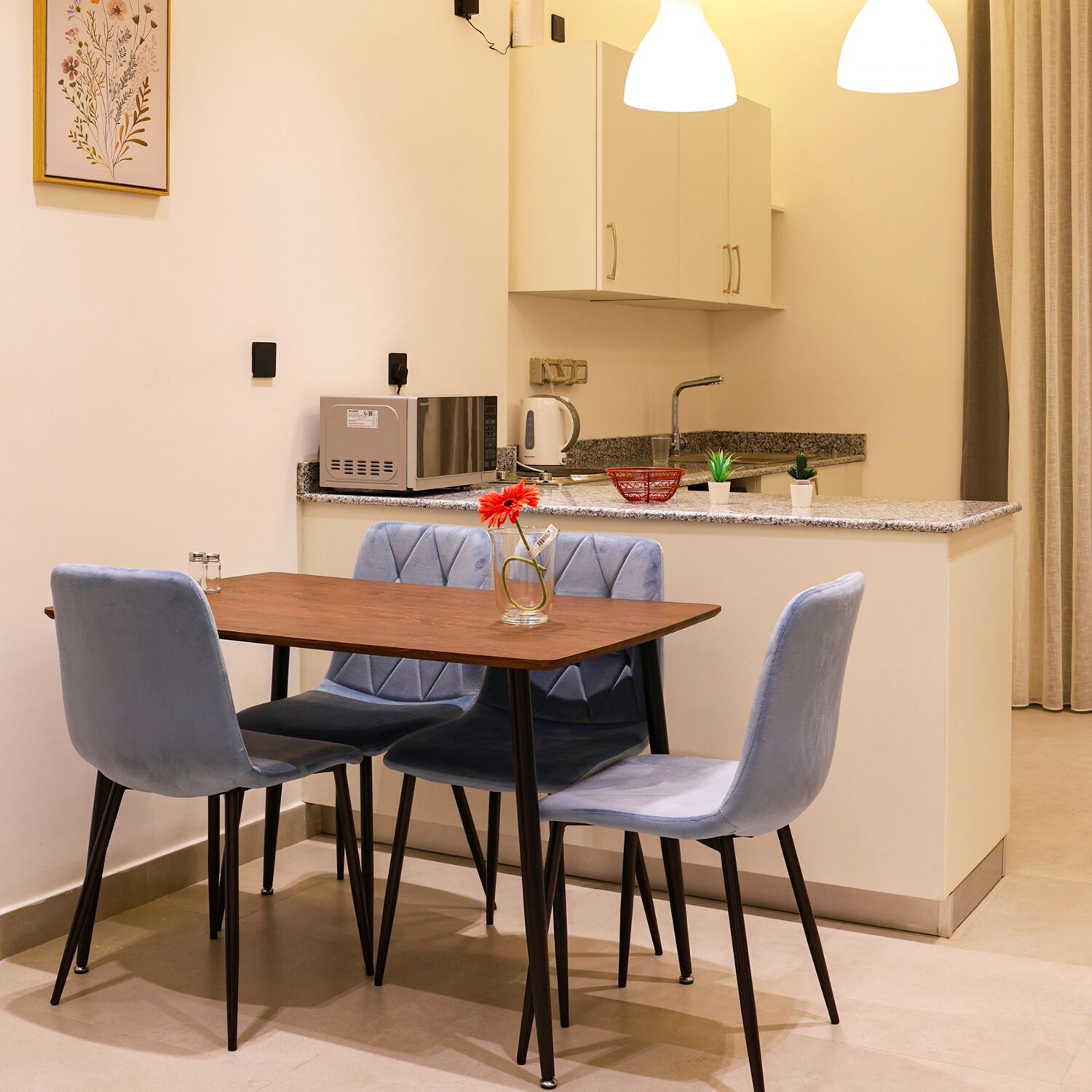 A compact kitchen with a dining area, featuring a microwave, toaster, and small sink.
