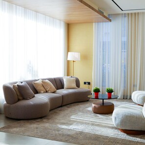 A modern living room with a sectional sofa, a round coffee table, and a floor lamp. - BHomed Shaab (Hawally)
