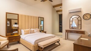 A bedroom with a large bed, bedside tables, a desk, a chair, a mirror, and a ceiling fan. - K2 Hotel by Green Pak Skardu (Skardu)