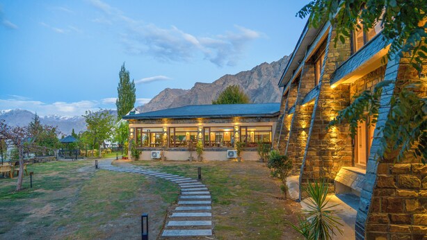 A stone building with a covered outdoor area, a stone pathway leading to the entrance, and mountains in the background. - K2 Hotel by Green Pak Skardu (Skardu)