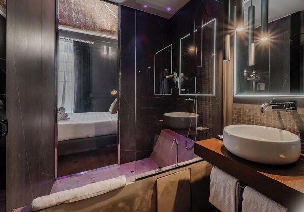 Ein modernes Badezimmer mit Duschkabine aus Glas, einem großen Waschbecken und einem Spiegel.