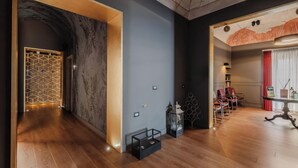 A modern hotel room with a wooden floor, a marble accent wall, a dining area with a table and chairs, and a large window with curtains. - Hotiday Palermo Palco Noir (Palermo)