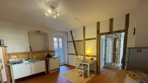 A compact kitchen with a dining area, a built-in stove, and a refrigerator.