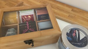 A wooden box with compartments containing various tea bags.