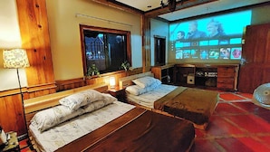 A cozy room with two wooden beds, a TV screen displaying a movie, and a window with a view of a building. - Room-prime Family Masters Room GF in Cam (Baguio)