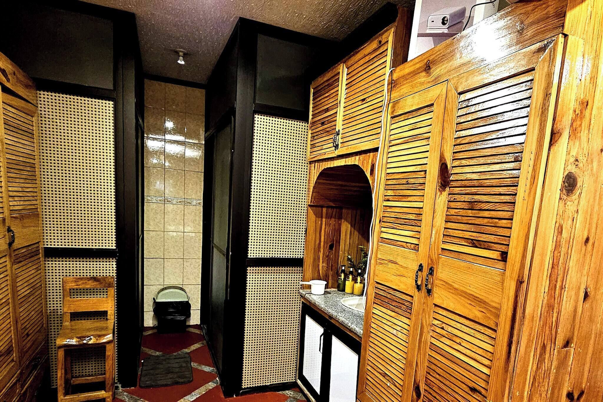 A traditional Japanese-style bathroom with wooden cabinets, a sink, and a toilet.