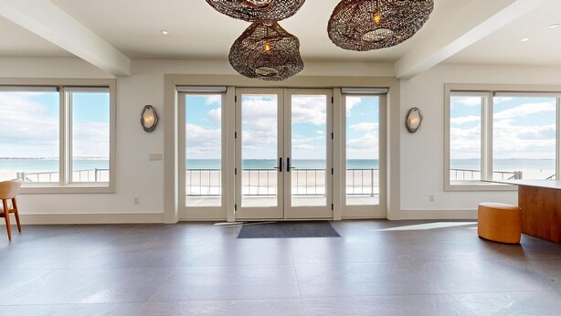 Una habitación amplia con ventanas grandes, vista a la playa y un diseño de techo moderno.
