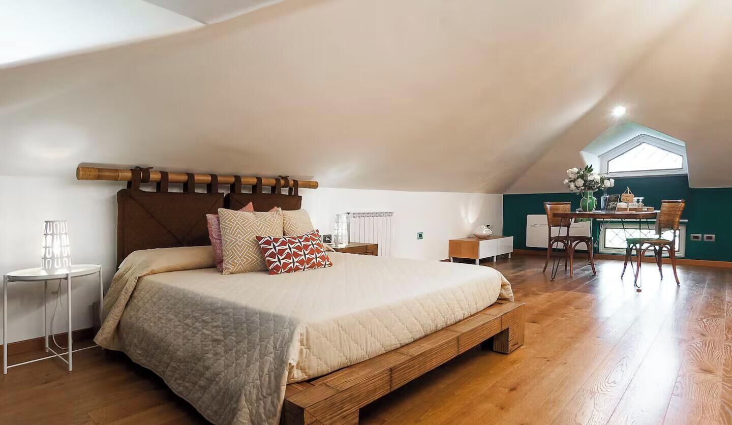 Una camera da letto con un letto di legno, una scrivania e una sedia.