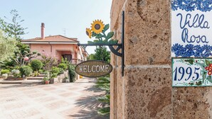 A welcome sign, a villa named 'Villa Rosa' with a year '1995', and a building with a tiled roof. - Villa Rosa Lifestyle B&B (Sessa Aurunca)