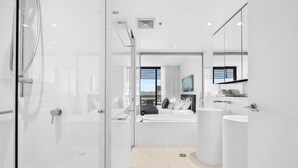 A modern bathroom with a glass shower enclosure, a large bathtub, and a separate sink area. - Dream Getaway on Level 29 with Breathtaking Ocean Views in Oracle Broadbeach! (Gold Coast)