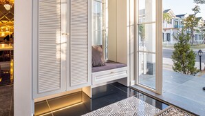 A modern interior with a built-in bench, large windows, and a patterned rug. - Villa LFP Novaworld Phan Thiet (Tien Thanh)