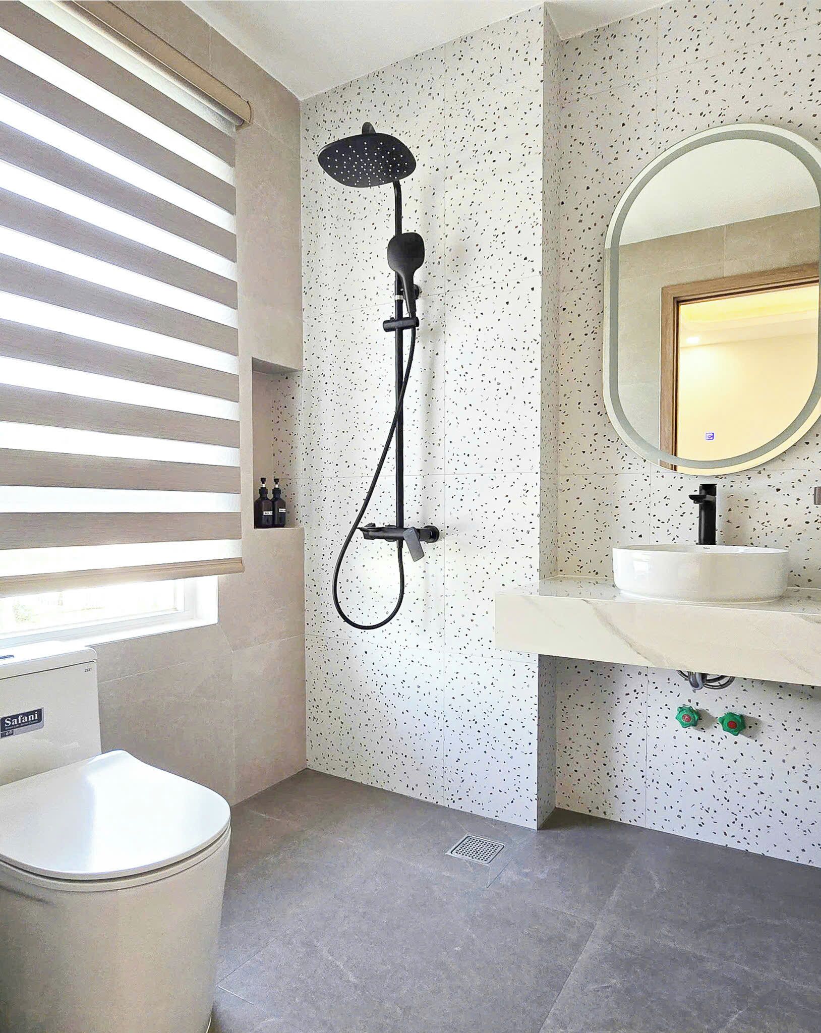 A bathroom with a shower, a sink, and a toilet.