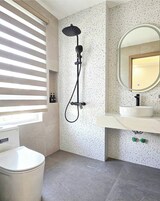 A bathroom with a shower, a sink, and a toilet.