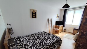 Makuuhuone, jossa on sänky, tikkaat, tuoli, työpöytä ja ikkuna.