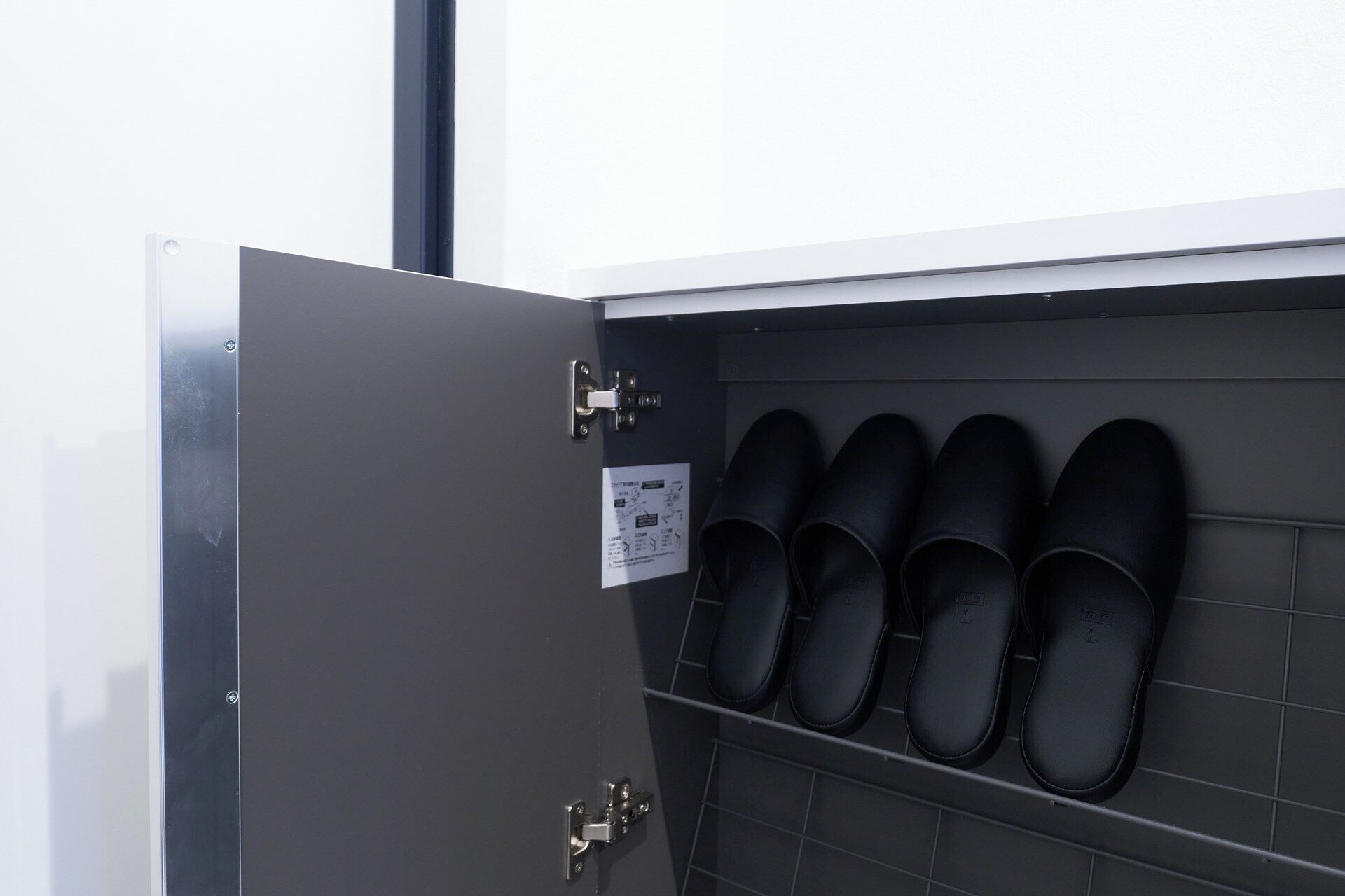 A shoe storage unit with multiple pairs of black shoes.