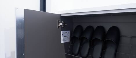 Un mueble para guardar zapatos con varios pares de zapatos negros.