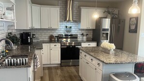 A modern kitchen with white cabinets, a stainless steel range, and a built-in oven. -  Goshen Lake Golf Club Retreat (Augusta)