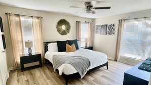 A bedroom with a bed, a nightstand, a ceiling fan, and a window with blinds. -  Goshen Lake Golf Club Retreat (Augusta)