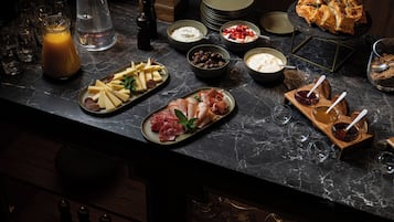 A well-organized buffet with various cheeses, meats, and spreads.