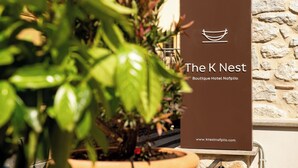 A sign for The K Nest Boutique Hotel Nafplio with a website URL.