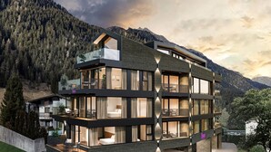 A modern multi-story building with large windows and balconies, surrounded by a mountainous landscape. - Chalet Fliana (Ischgl)