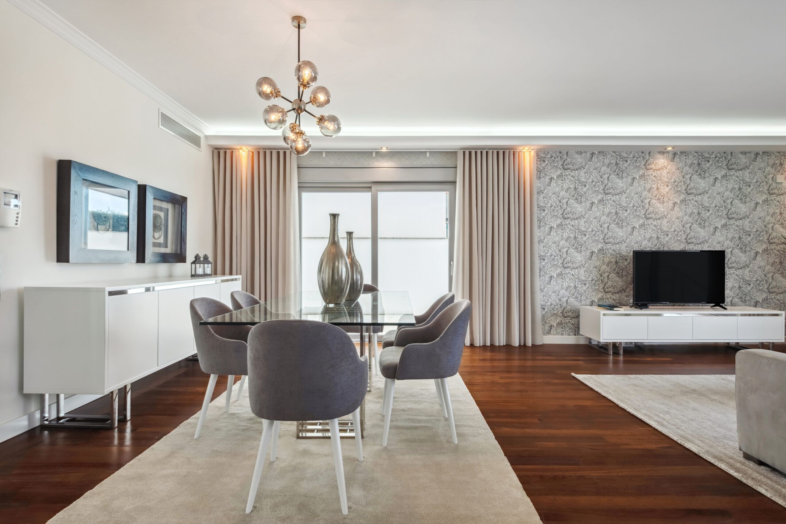 A modern living room with a dining area, a TV, and a fireplace.