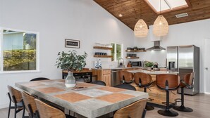 A modern kitchen with wooden cabinets, a built-in oven, and a stainless steel refrigerator.