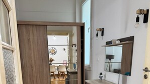 A modern kitchen with wooden flooring, a built-in bench, a sink, and a mirror above the countertop. - Athenian Stay Kolonaki Apartment (Athens)
