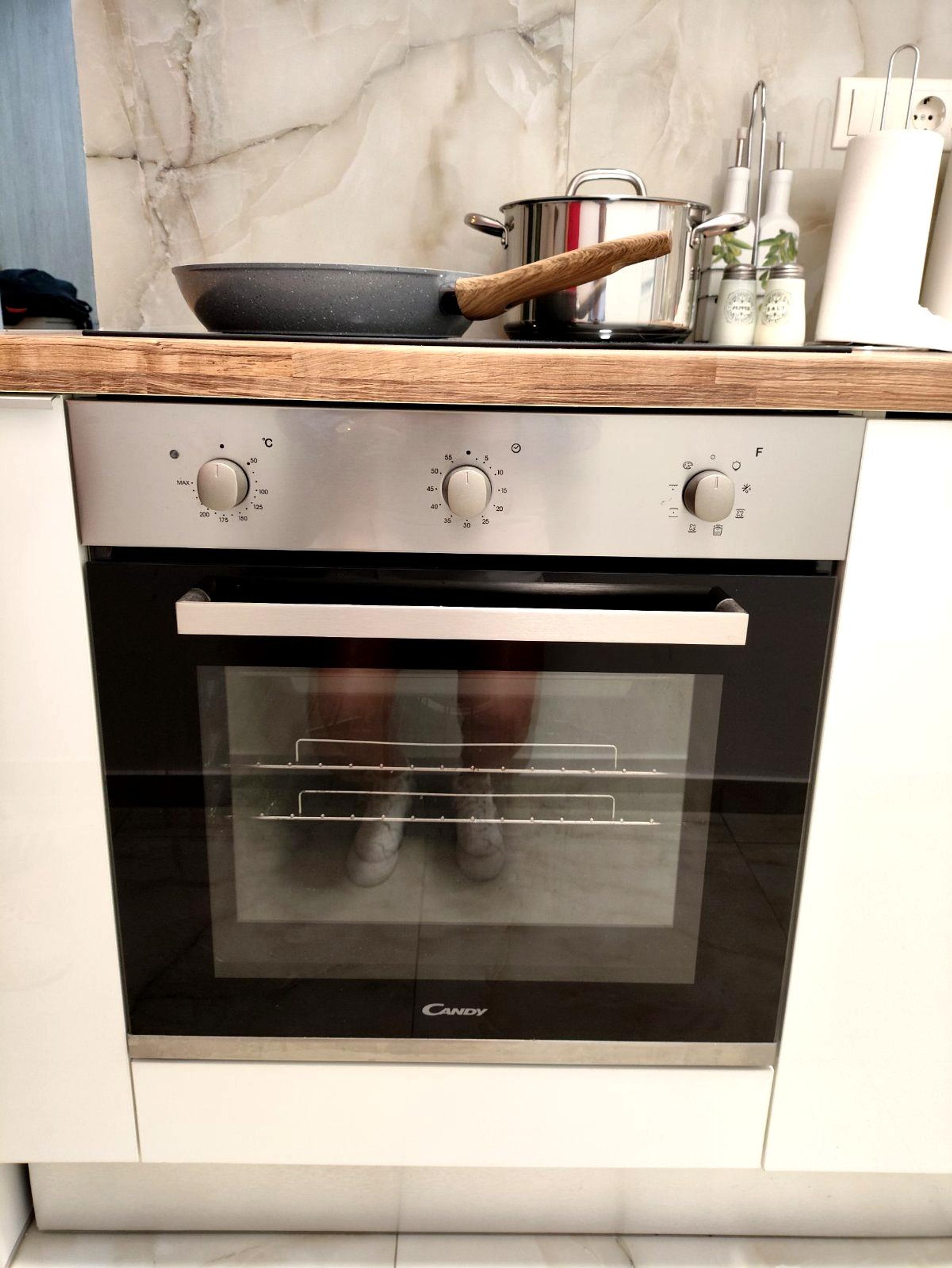 Une cuisine dotée d’un four moderne et d’un plan de travail en bois.