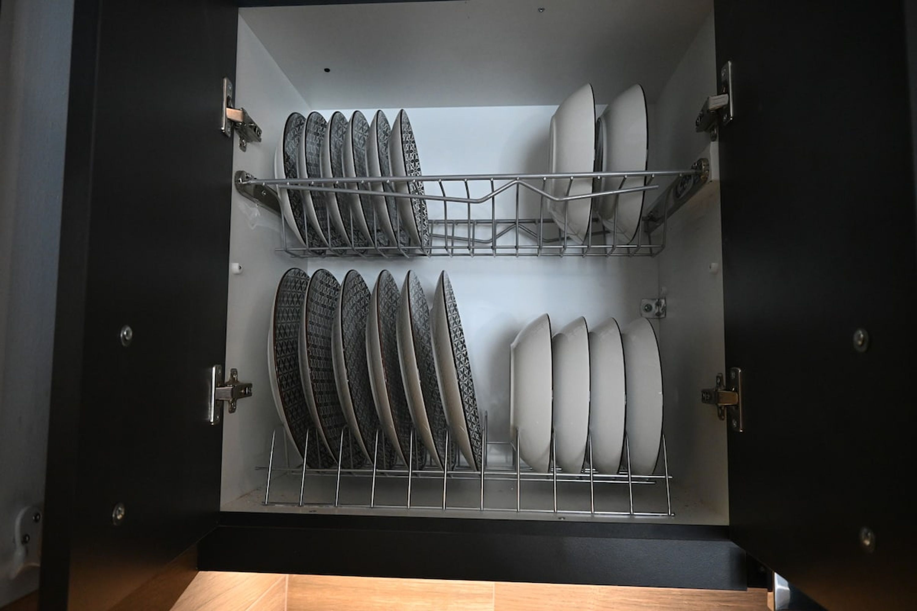 Un lave-vaisselle ouvert, avec plusieurs étagères contenant des assiettes et des bols.