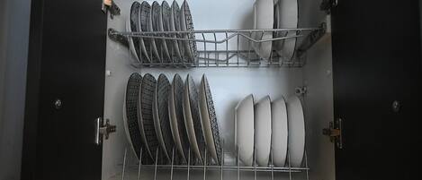 An open dishwasher with multiple racks holding plates and bowls.
