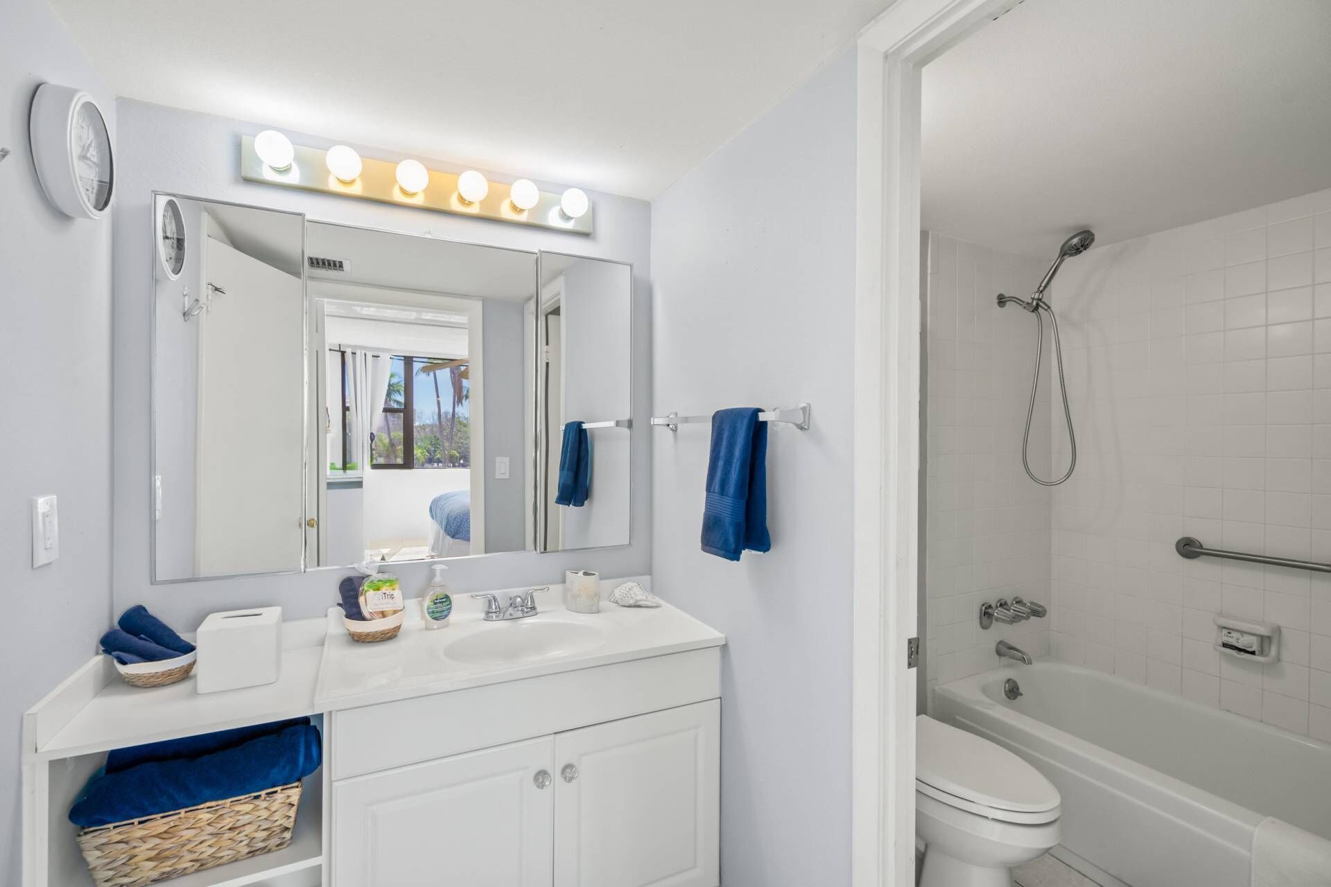 Une salle de bain comprenant un meuble-lavabo, un miroir, un évier, des toilettes et une douche.