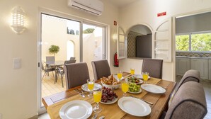 Un comedor con una mesa preparada para el desayuno, que incluye croissants, uvas y zumo de naranja.