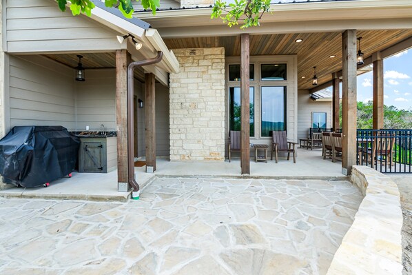 A covered patio area with stone flooring, wooden columns, and a barbecue grill. - Stunning Concan views & private swimming pool (Concan)