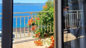 A balcony with a view of the sea and a garden with orange flowers. - Breladreams Apartment *** (Brela)